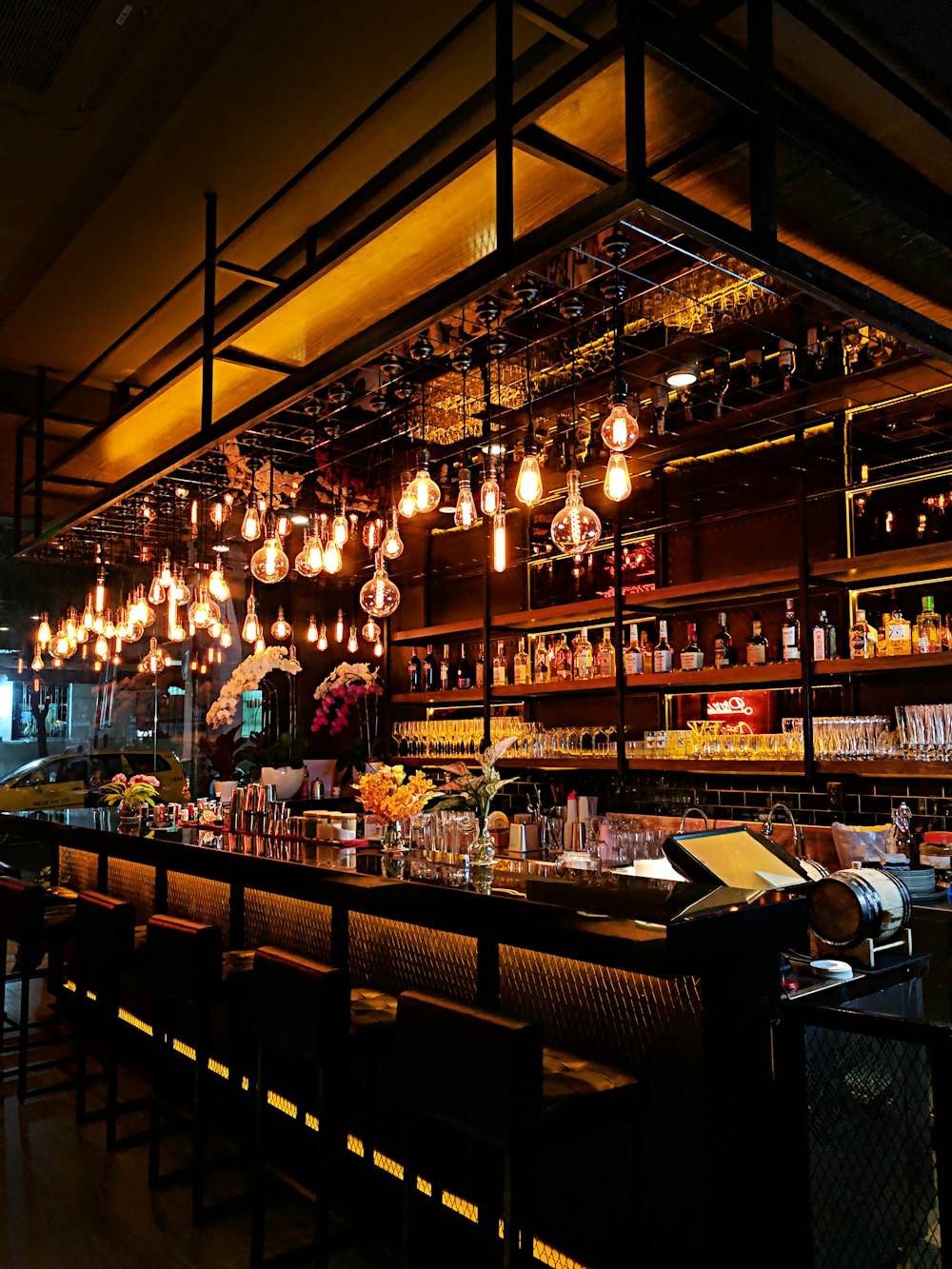 Warm, low-lit bar interior with hanging pendant lights