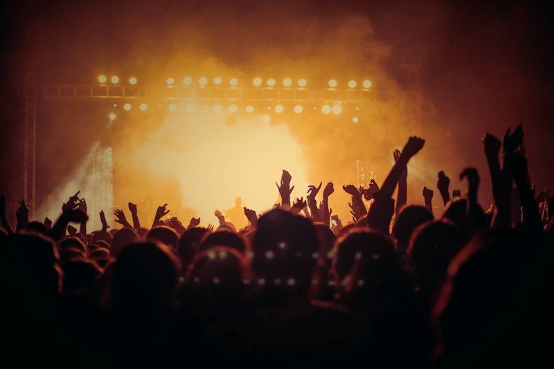 Crowd silhouettes lit gold under stage lights