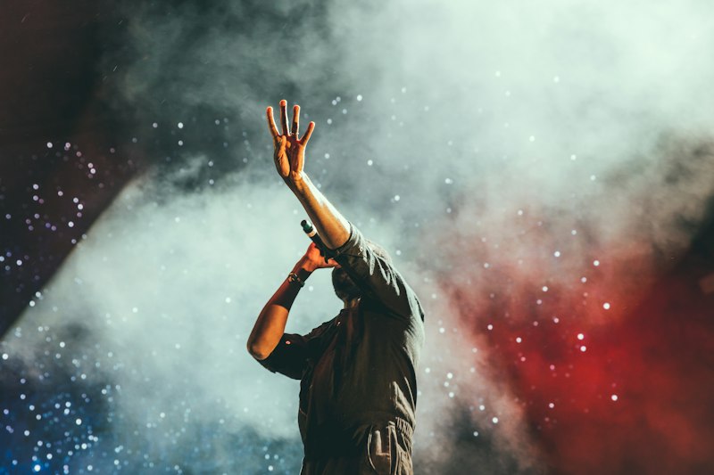 Hand raised in stage smoke and light